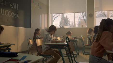 niños sentados en los escritorios de la escuela en el aula. estudiantes preparándose para la lección