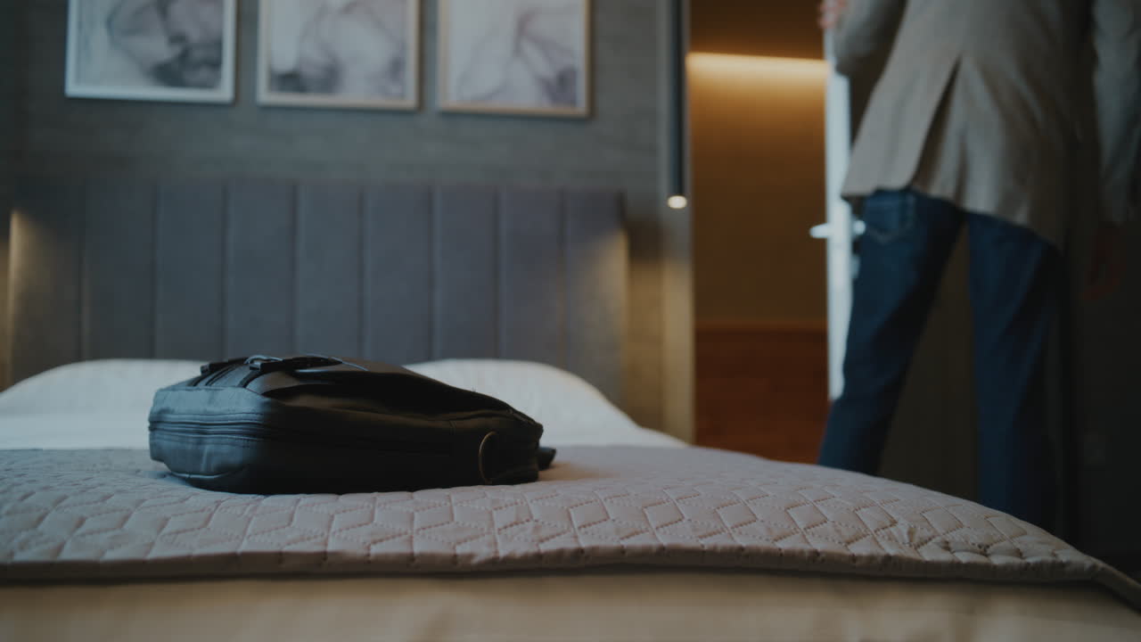 Man in Hotel Room with Backpack on Bed