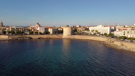 drone shot over the ancient city walls of alghero with a view of the bay and ocean