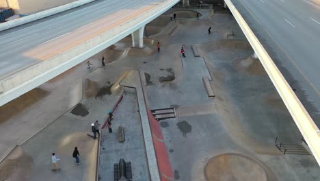 drone shot pushing through a skatepark under a highway