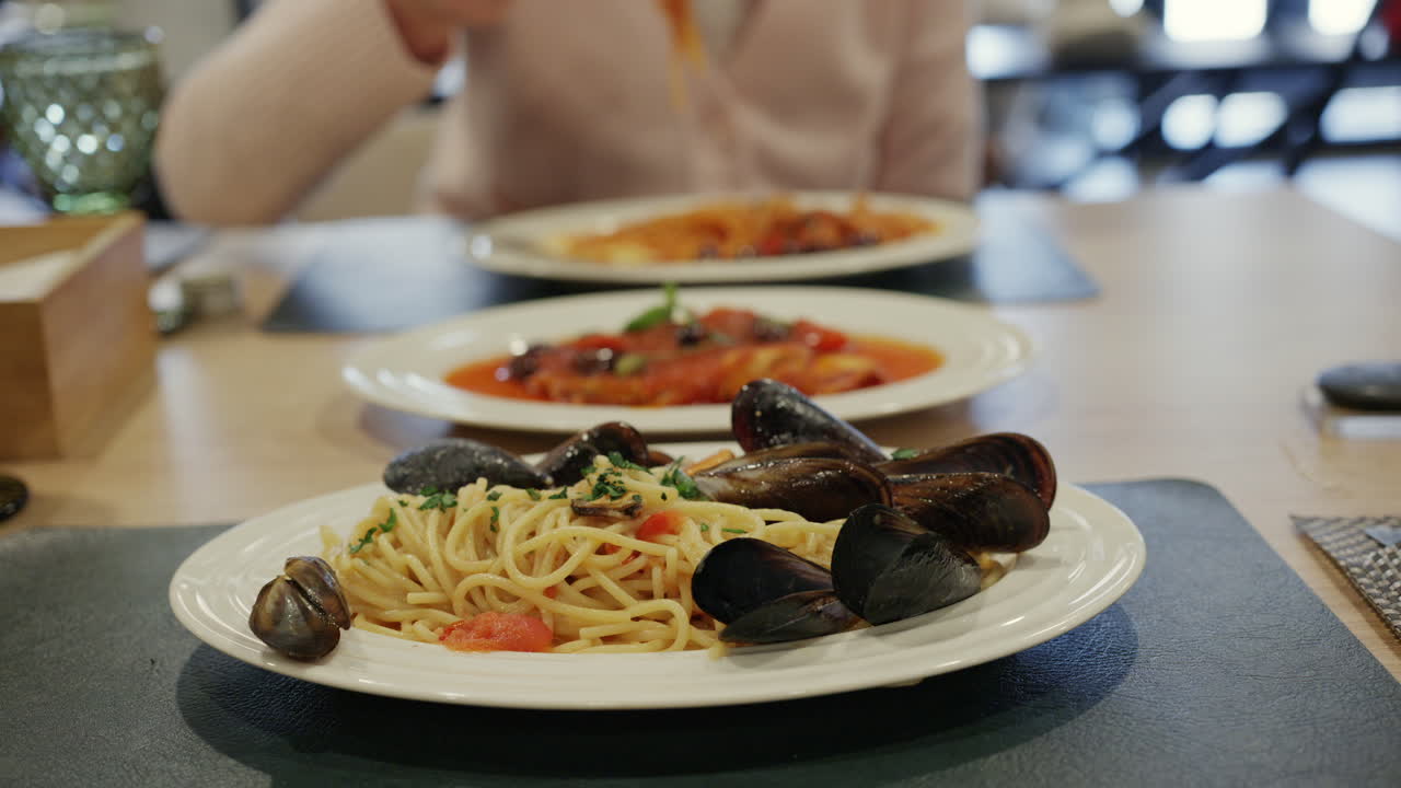 Piatto di spaghetti alle cozze con cozze fresche, aglio, erbe aromatiche e sugo di pomodoro leggero