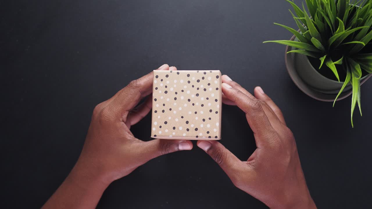 manos abriendo una caja de regalos vacía