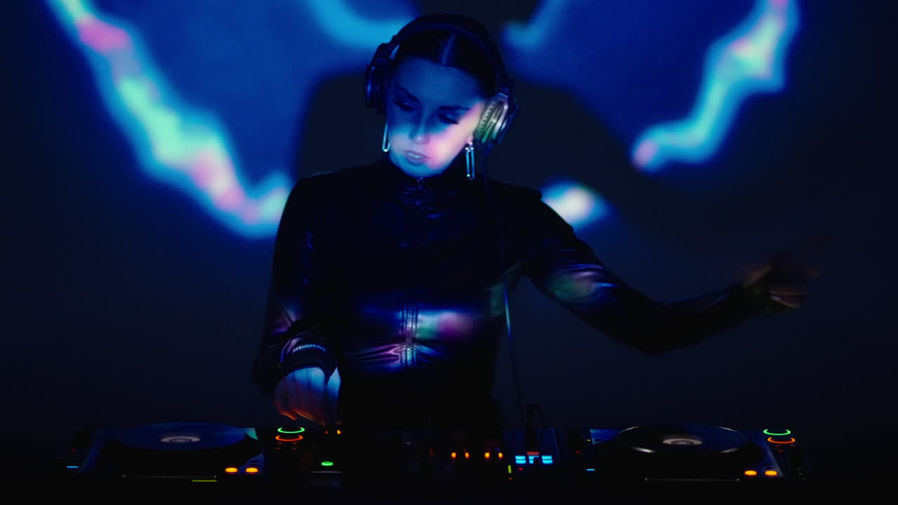 Female DJ performing on stage with a set of turntables.