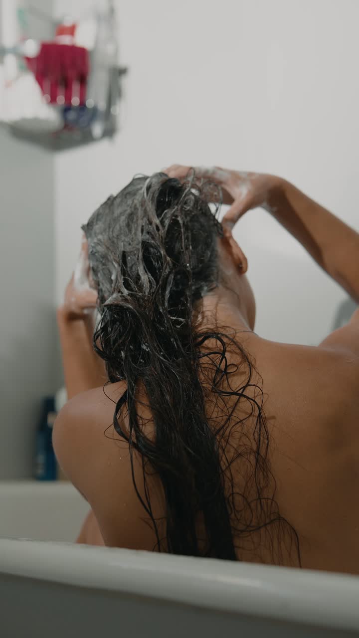 mujer lavando el cabello en la ducha