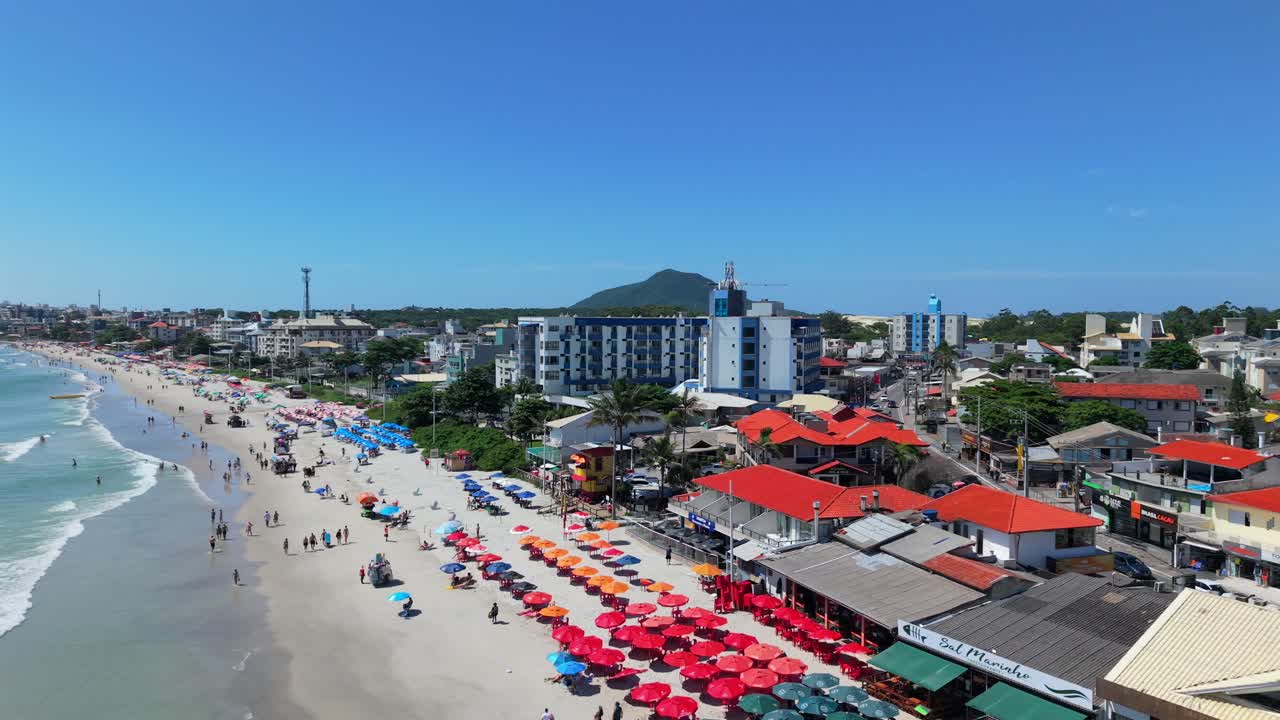 Brezilya, Santa Catarina, Florianopolis'teki Praia dos Ingleses yakınlarındaki kentsel sahil şeridi ve konutlar. Havadan sola doğru takip çekimiyle genel görünüm sunuluyor.