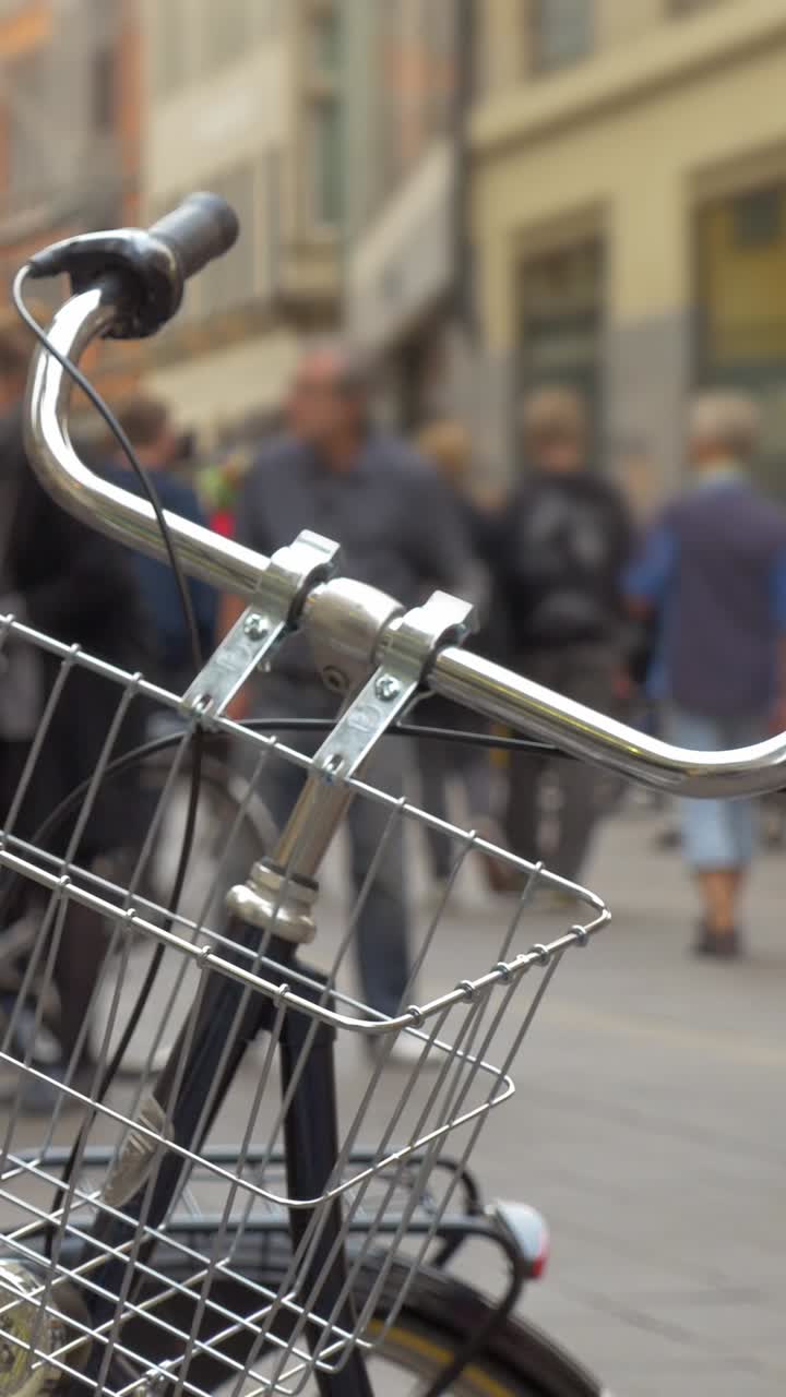 Bicycle Parked on Urban Street with People Walking in Background