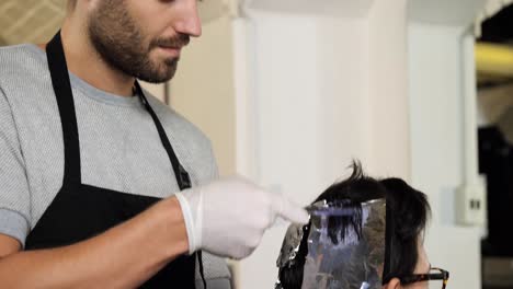 peluquero teñir el cabello del cliente