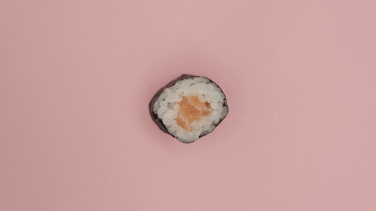 Sushimaakki pyörii ruusunpunaisella taustalla