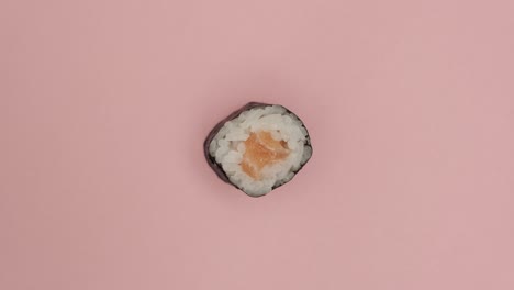 Sushi-roll-rotating-on-rosy-background