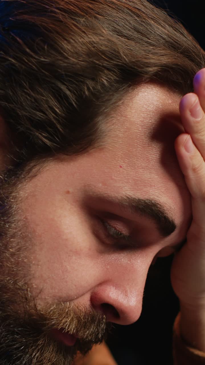 Primo piano di un uomo stressato che si sfrega gli occhi e pensa intensamente