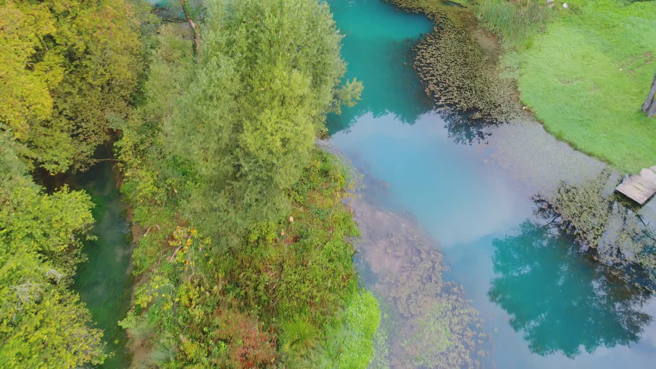 Fly over backwards shot of river in the middle of a forest, overflow dam. Aerial