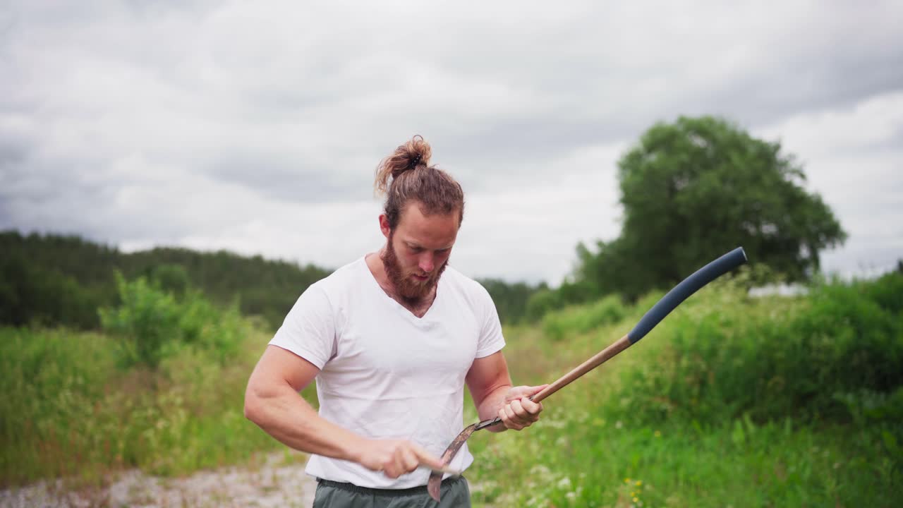 Male Gardener Sharpening His Sickle - medium shot