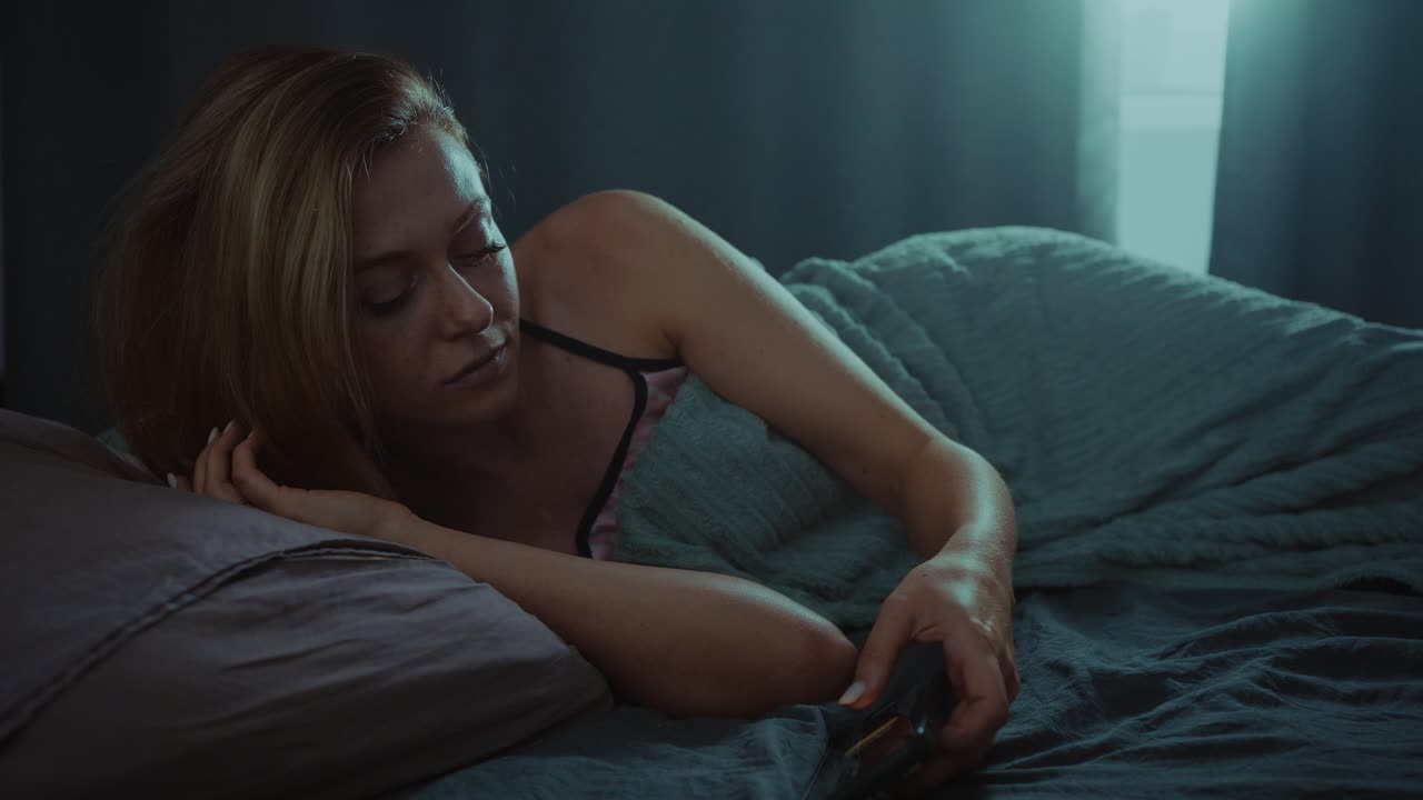 mujer usando el teléfono en la cama por la noche