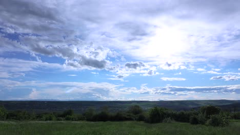 beautiful clouds over green landscape - time lapse