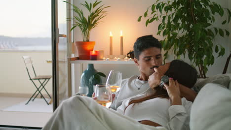 romantic family kissing flat interior closeup. couple resting together with wine