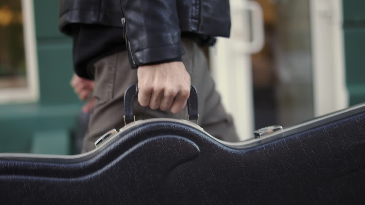 Man Carrying Guitar Case in the city