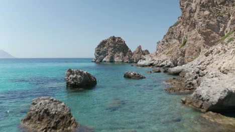 Low-flight-above-Turquoise-Blue-Ocean-Water-and-Rocky-Cliff-Coast-in-Greece