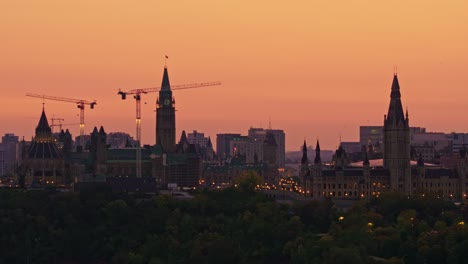 Langsamer-Abflug-Des-Kanadischen-Parlaments-Aus-Der-Luft,-Der-Seine-Silhouette-über-Einem-Wunderschönen-Orangefarbenen-Herbsthimmel-Zeichnet