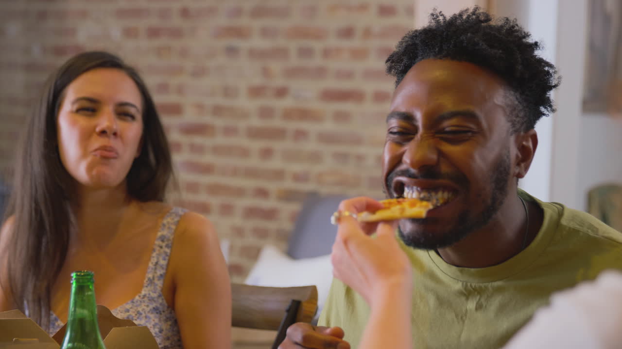grupo multicultural de amigos disfrutando de una fiesta de cerveza y pizza en casa juntos