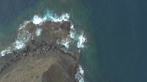 Toma-De-Arriba-Hacia-Abajo-De-Drones-De-Olas-Que-Rebotan-En-Las-Rocas-En-La-Costa-Rocosa