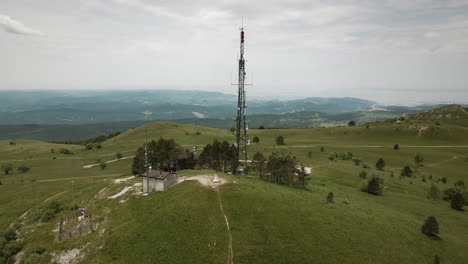 drone shot of a radio tower on top of mountain slavnik with a view on nearby mountains and adriatic sea