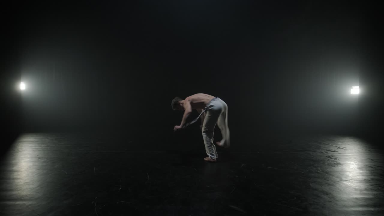 Lottatori di Capoeira che eseguono mosse dinamiche sul palco. Arti marziali, danza e acrobazie in azione. Atleti a torso nudo che mostrano forza, flessibilità e tecnica sotto i riflettori