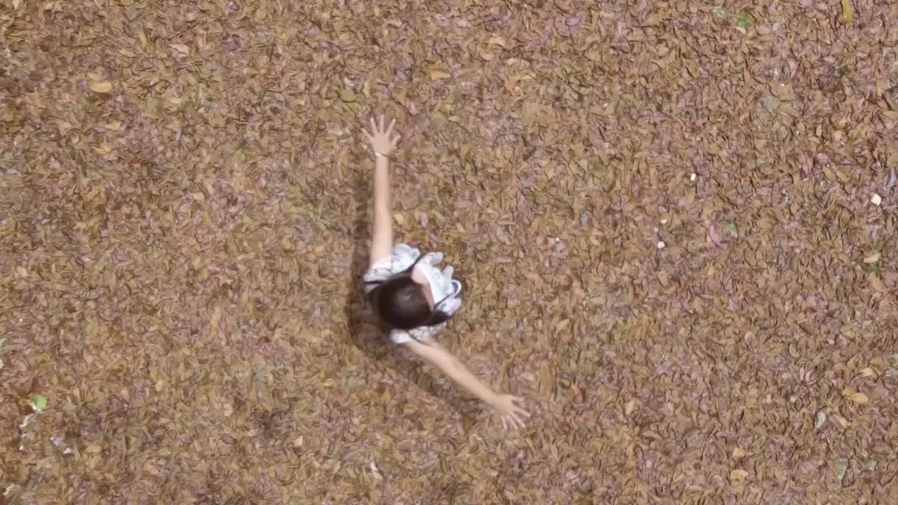 a girl with telekinetic power standing on leaves fall season