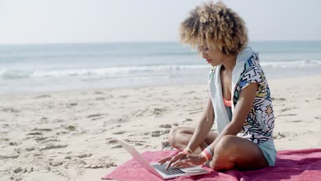 Chica-Trabajando-Con-Una-Computadora-Portátil-En-La-Playa-De-Arena