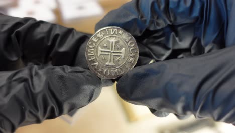 collector examining portuguese gold coin from the medieval age