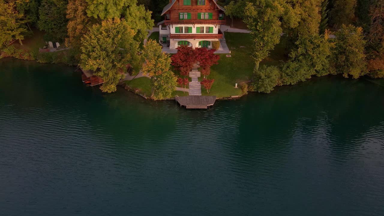Dronebillede af et fredfyldt søhus om efteråret ved Bled-søen, Slovenien