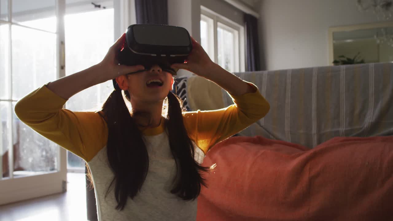 chica asiática feliz en casa, sentada en el suelo en la sala de estar usando auriculares vr