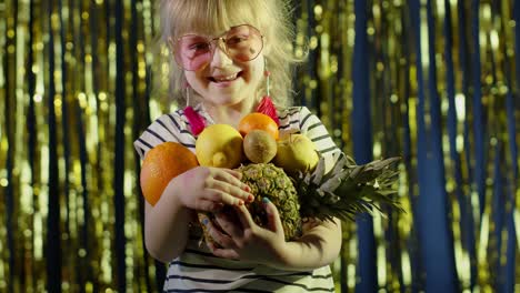 Trendy-girl-in-pink-sunglasses-posing-looking-at-camera-with-bunch-of-fruits-in-hands-in-night-club