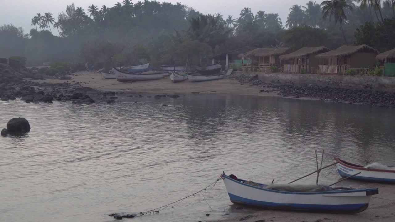 toma panorámica a través de la fila de coloridas cabañas de playa con techo de paja en la costa de la playa de indian, goa