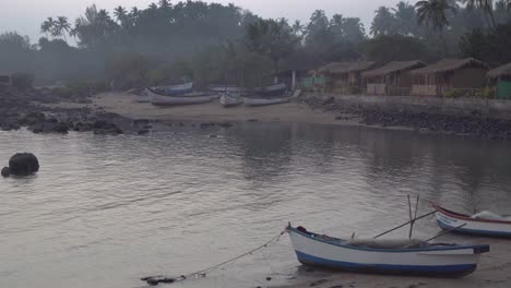 Panning-shot-across-row-of-grass-thatched-colourful-beach-huts-on-the-shoreline-of-Indian,-Goa-beach