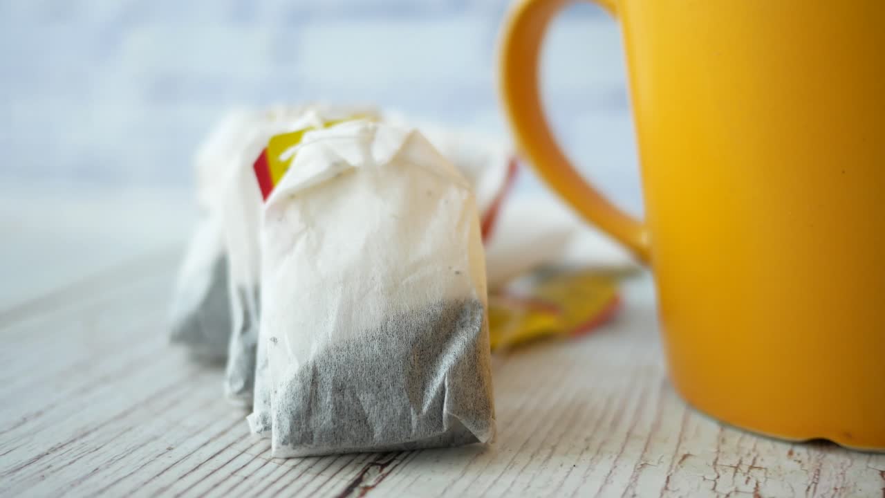 bolsas de té y una taza amarilla