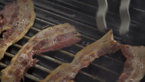 grilling bacon pieces on hot pan