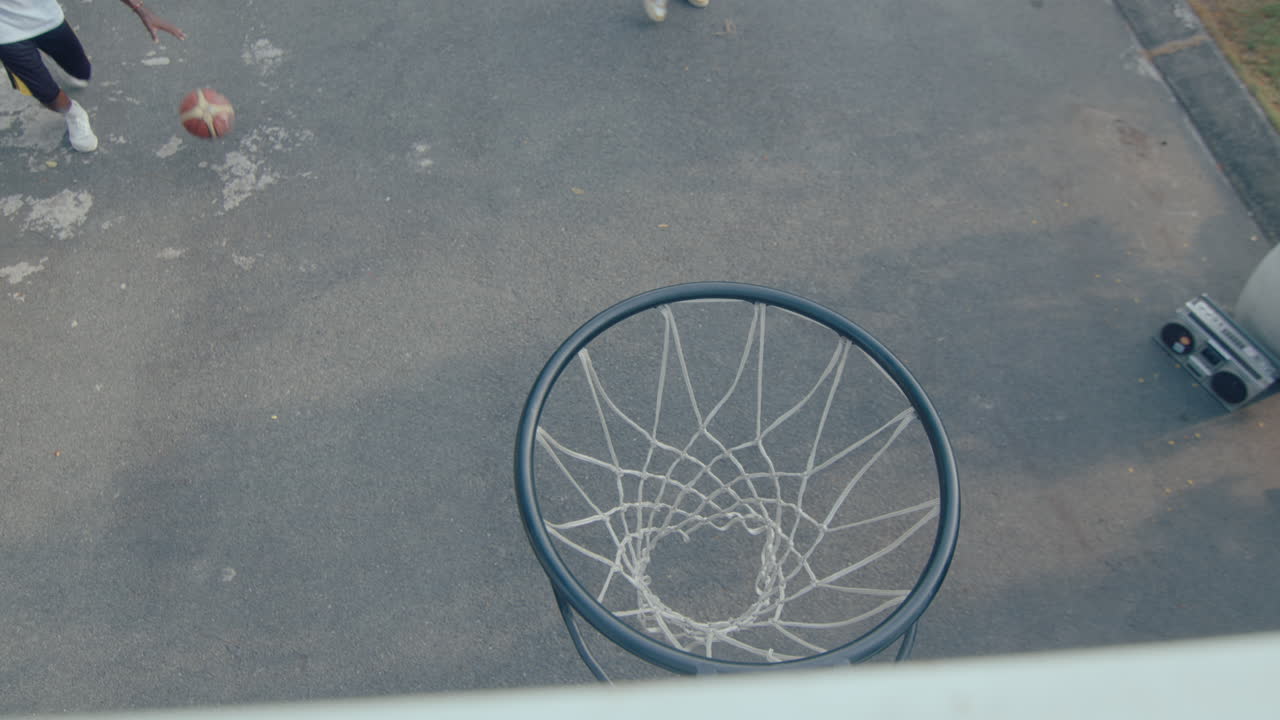 Black Man Shooting Basketball Through the Hoop when Playing Outdoor
