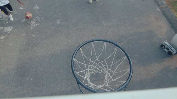 Black Man Shooting Basketball Through the Hoop when Playing Outdoor