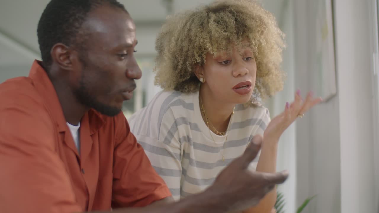 Young Couple Discussing Something on Laptop at Home