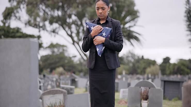 Funerale, morte e una donna triste con una bandiera americana