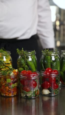 chef conservando verduras en frascos de vidrio