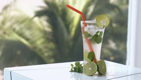 thin transparent curtain swings and mojito stands on table