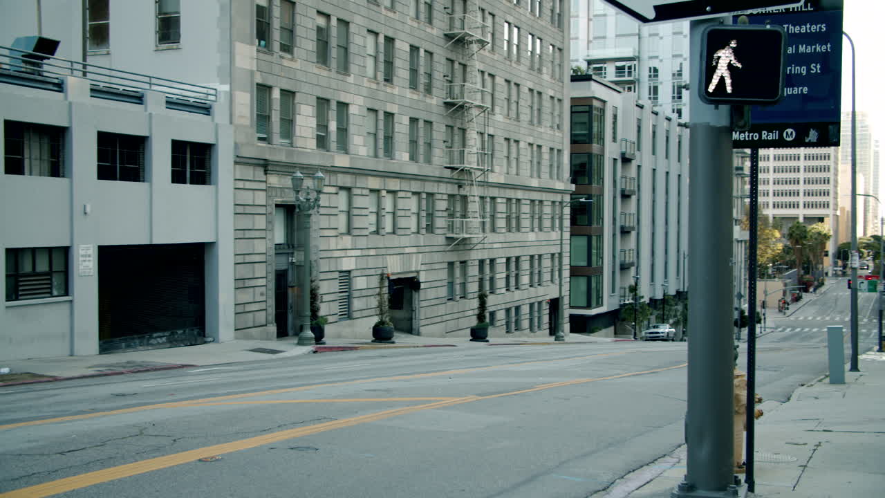 A wide view of a sloping city street lined with tall buildings