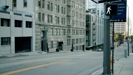 a wide view of a sloping city street lined with tall buildings