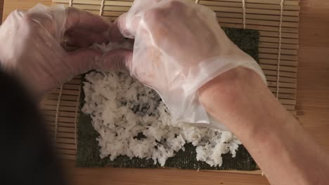 topshot of chef preparing sushi rolls in the kitchen