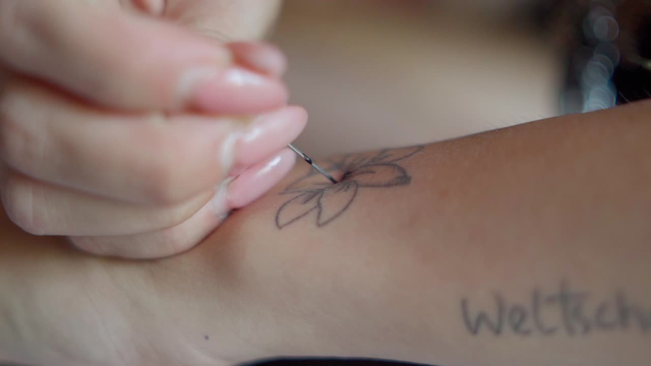 Girl doing a tattoo on herself HFR