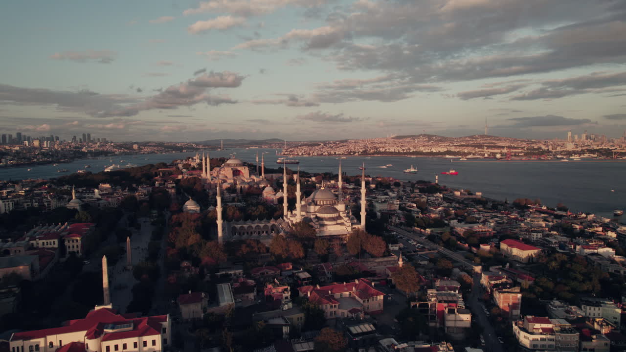 Unique view on Hagia Sophia and the Sultan Ahmed Mosque at sunset with beautiful lights in Istanbul, red cloudy sky with copy space