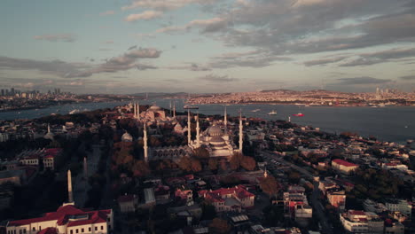 unique view on hagia sophia and the sultan ahmed mosque at sunset with beautiful lights in istanbul, red cloudy sky with copy space