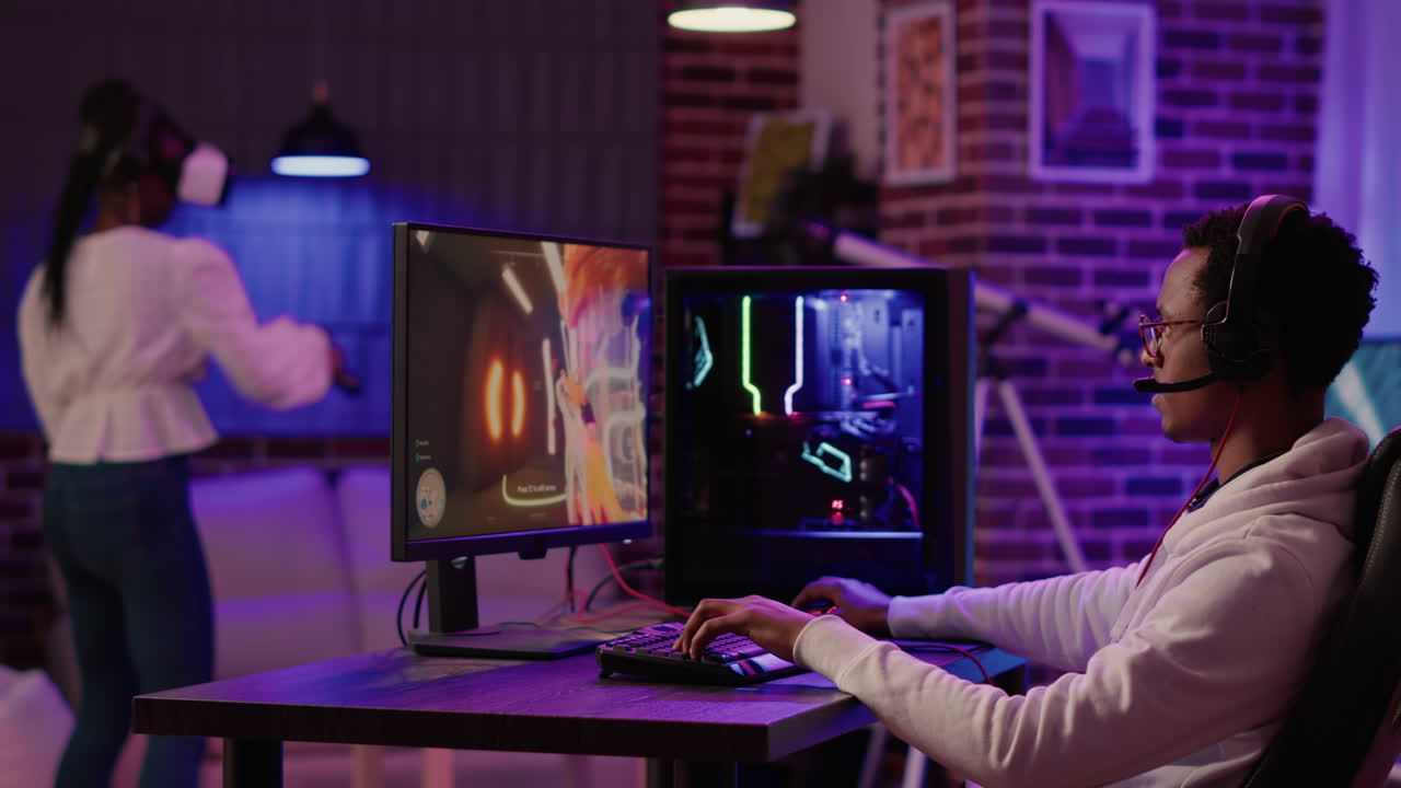 African american man having fun playing intense first person shooter while girlfriend is relaxing in virtual reality