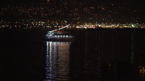 touristic ship sailing along night city